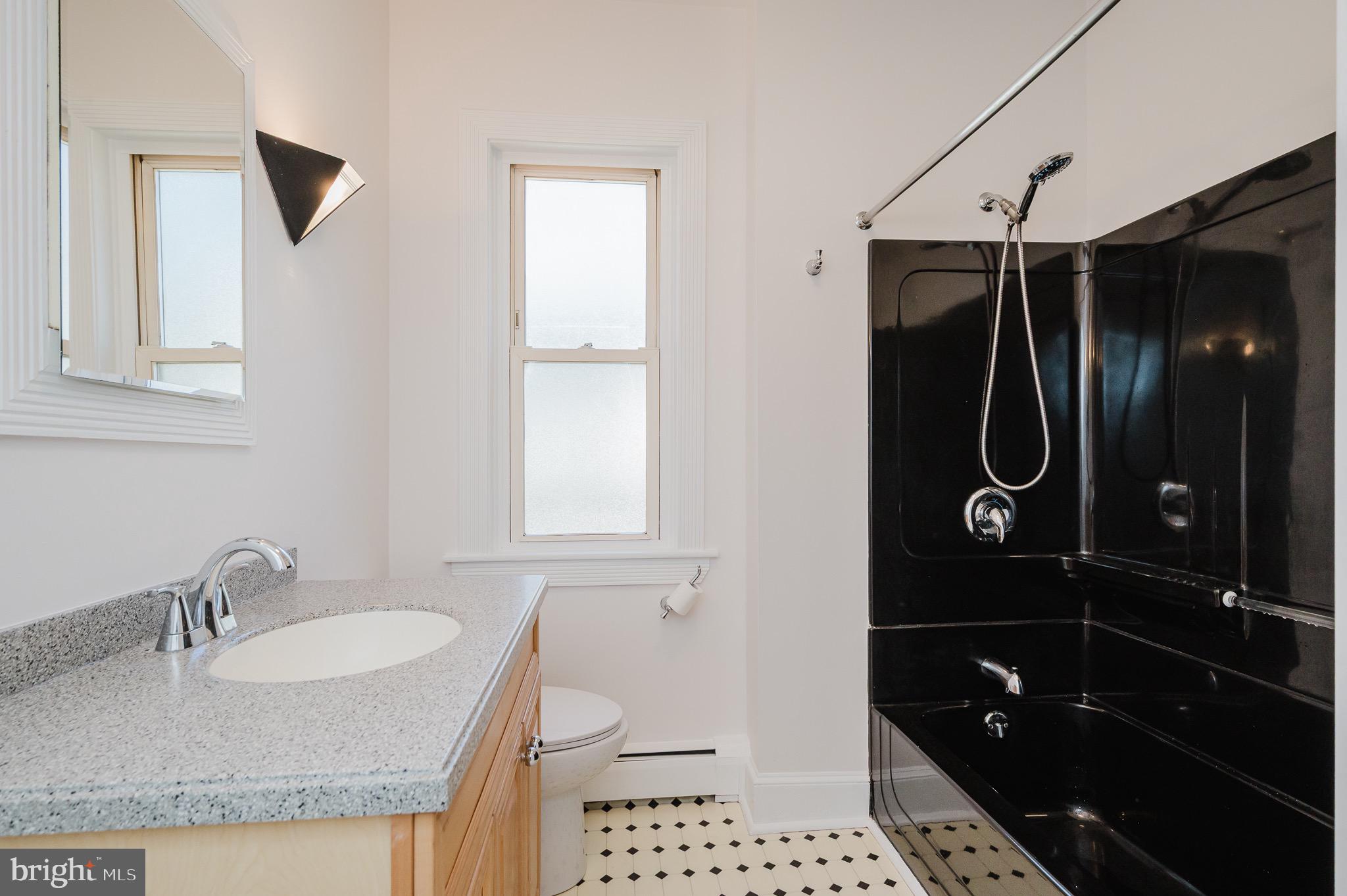 3518 Poole Street Baltimore, MD 21211 - Photo 22 of 59 a bathroom with a granite countertop sink toilet and shower