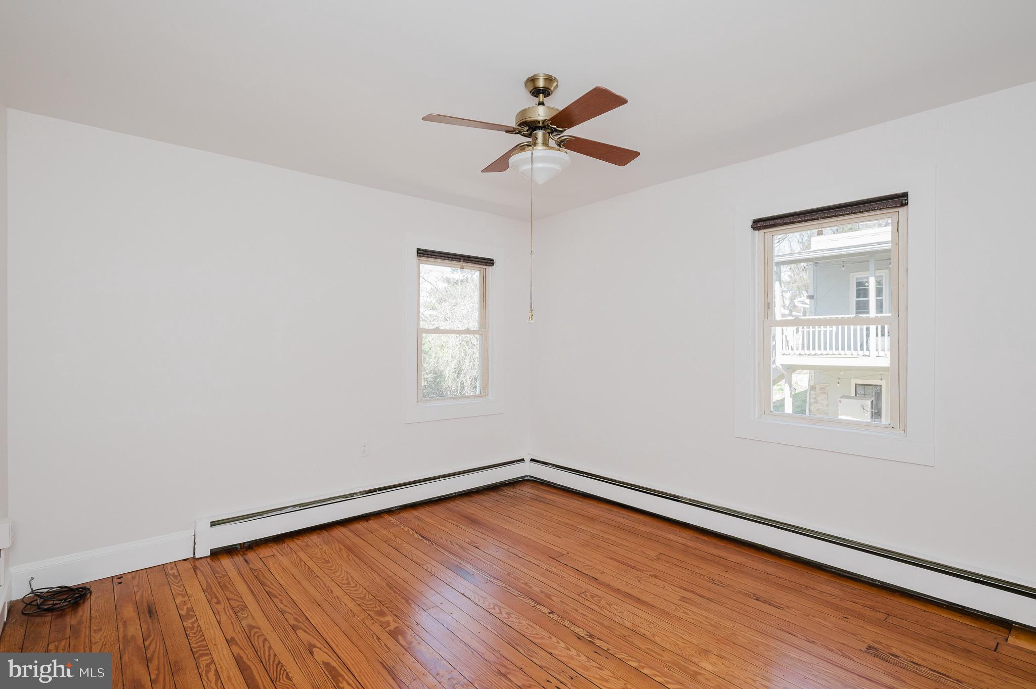 3518 Poole Street Baltimore, MD 21211 - Photo 23 of 59 an empty room with wooden floor fan and windows