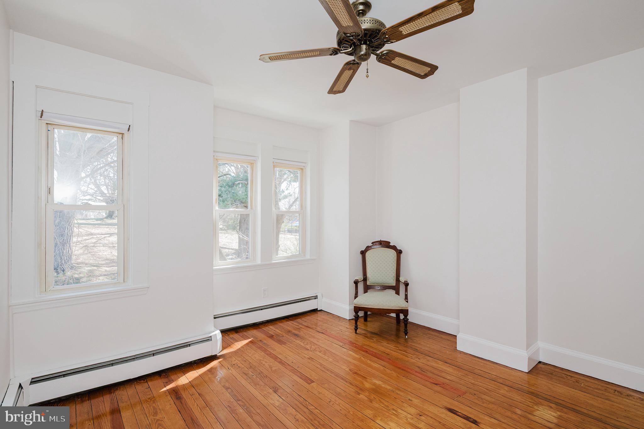 3518 Poole Street Baltimore, MD 21211 - Photo 30 of 59 an empty room with wooden floor fan and windows