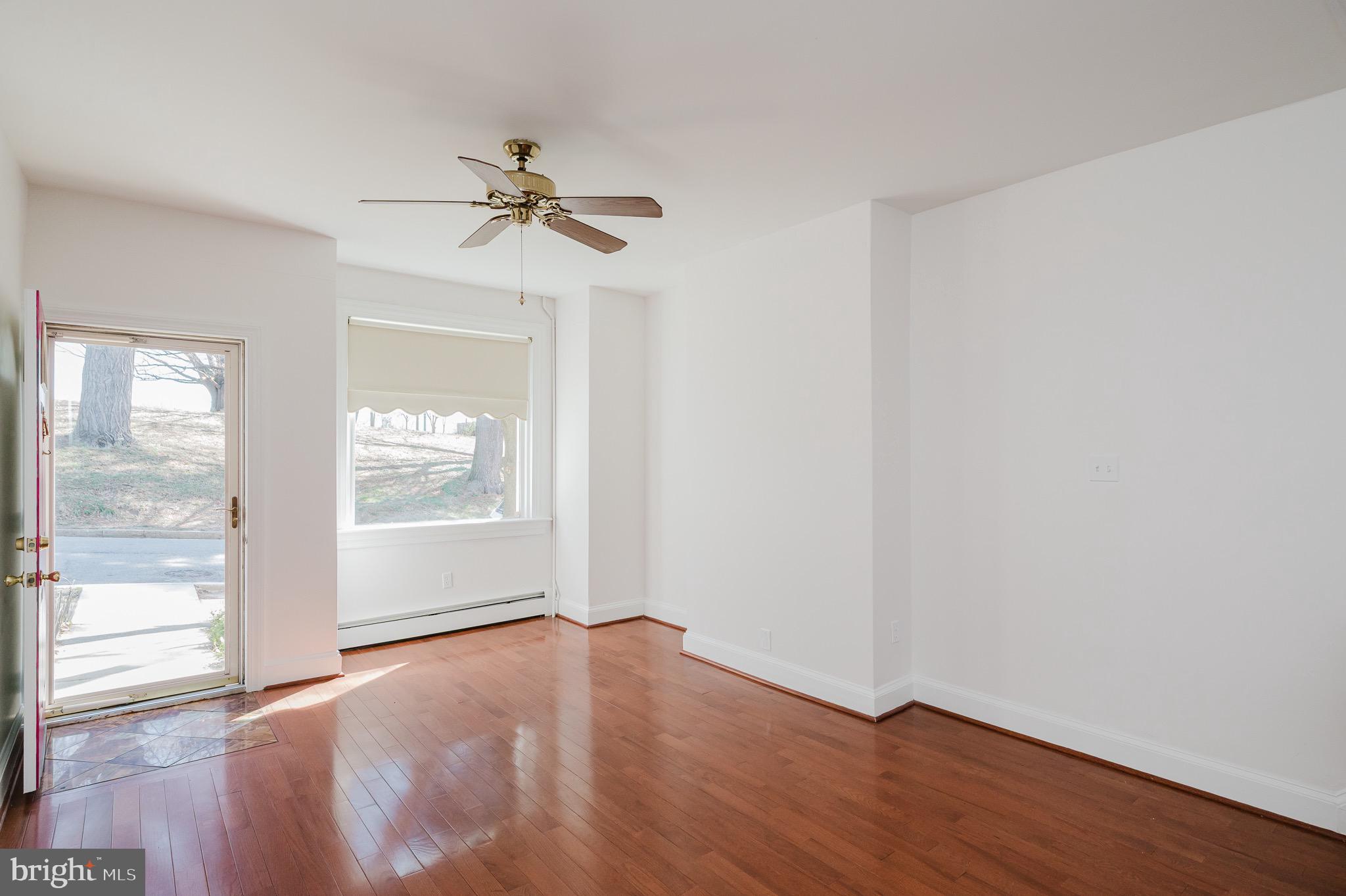 3518 Poole Street Baltimore, MD 21211 - Photo 6 of 59 an empty room with wooden floor fan and windows