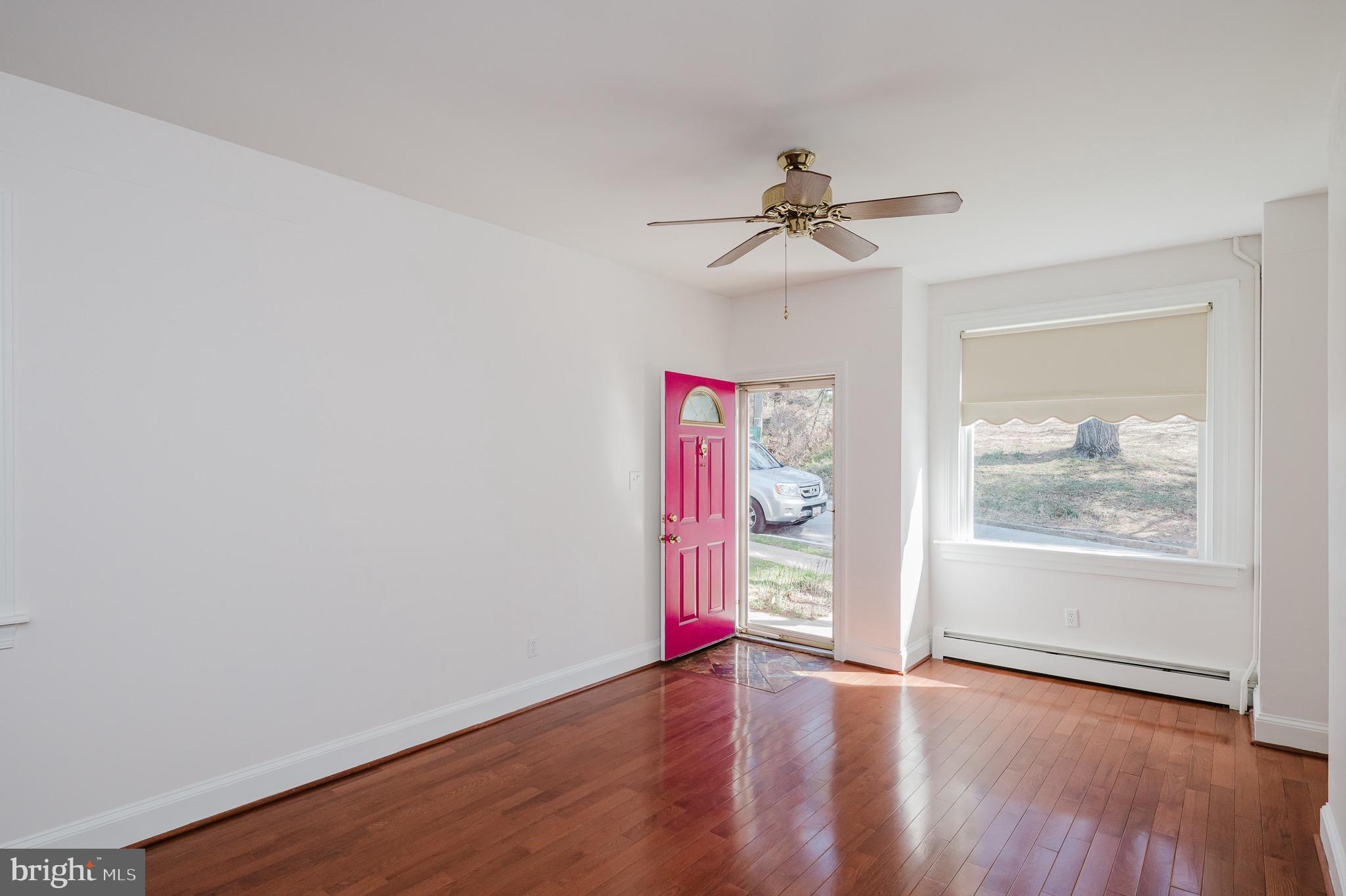3518 Poole Street Baltimore, MD 21211 - Photo 7 of 59 an empty room with wooden floor chandelier fan and windows