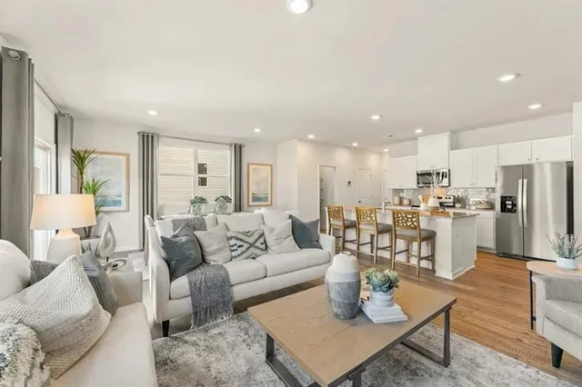 a living room with furniture kitchen and a table