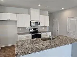 a kitchen with stainless steel appliances granite countertop a stove a sink and a refrigerator