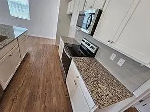a view of a hardwood floor and an entryway