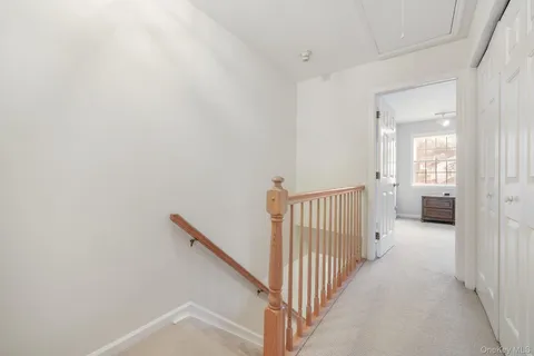 a view of a hallway with a hallway to a livingroom with furniture