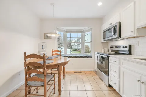a kitchen with stainless steel appliances granite countertop a stove a sink dishwasher and a refrigerator with wooden cabinets