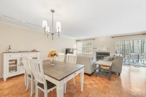a dining room with furniture a chandelier and wooden floor