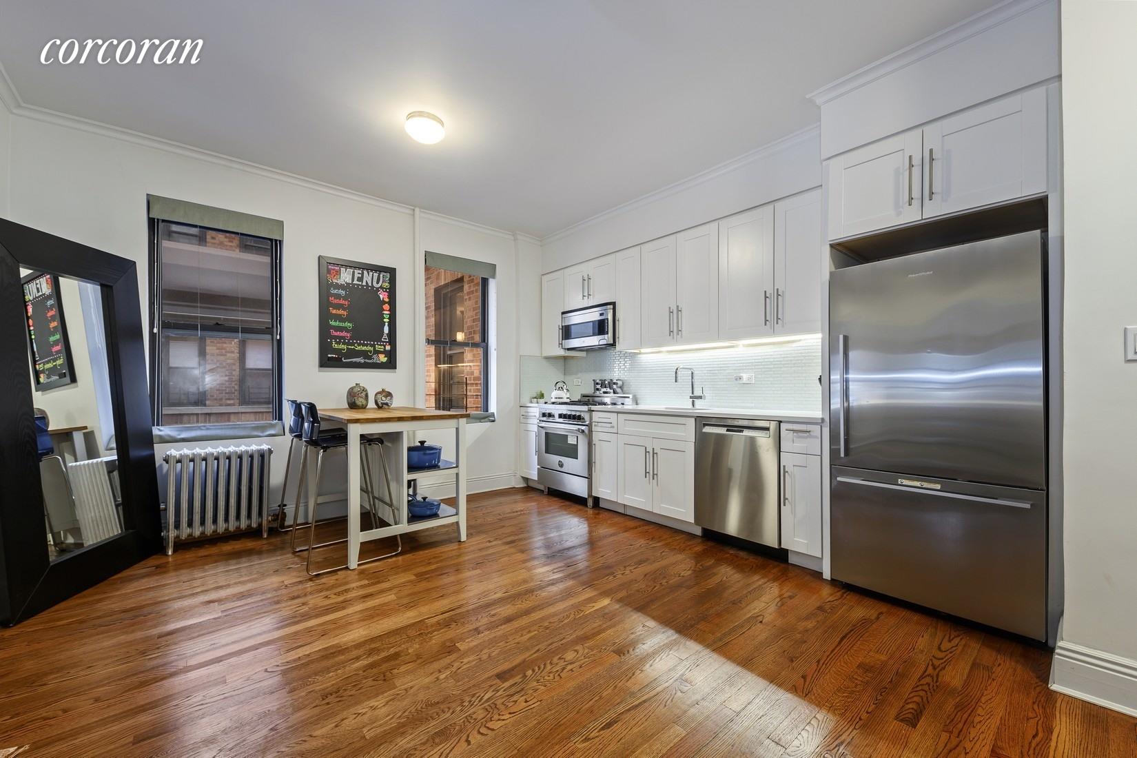 a kitchen with stainless steel appliances a refrigerator sink and wooden floor