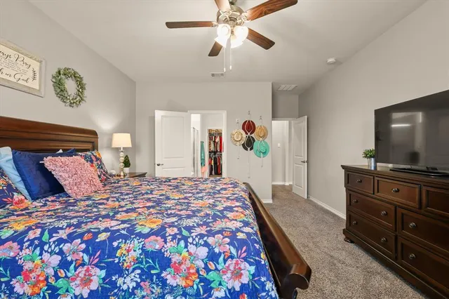 a bedroom with a bed and dresser with mirror