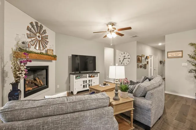 a living room with furniture a flat screen tv and a fireplace