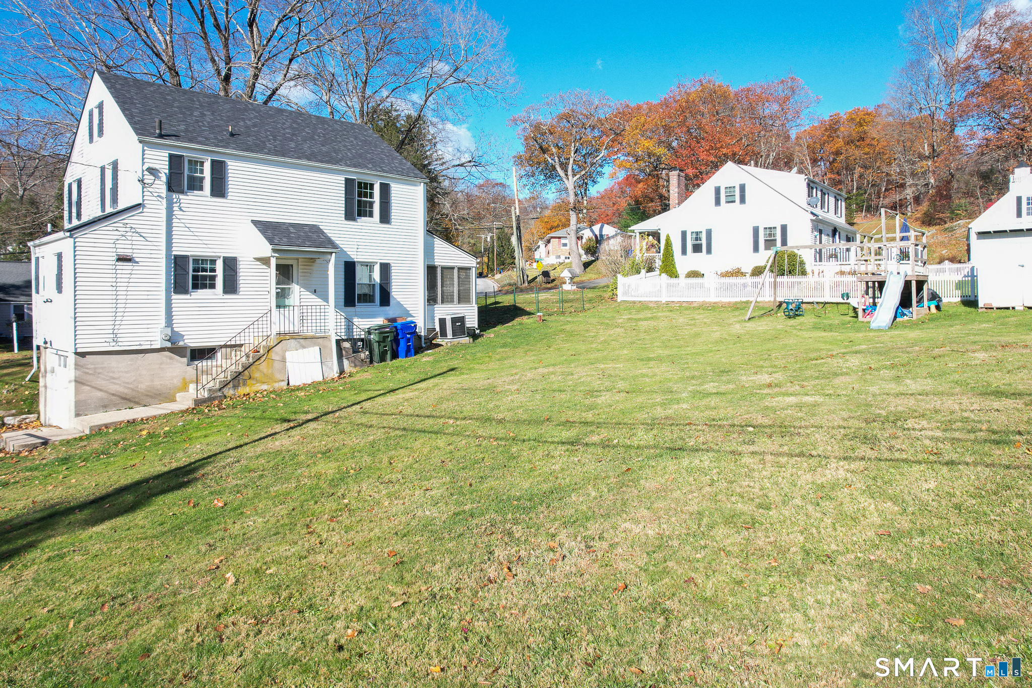 232 High Street Thomaston, CT 06787 - Photo 28 of 31 a view of a white house with a yard table and chairs