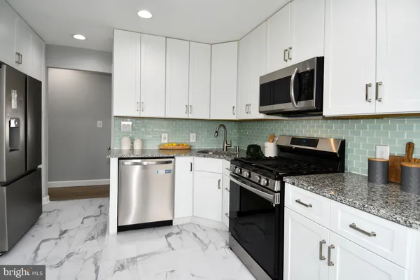 a kitchen with stainless steel appliances granite countertop a stove a refrigerator a sink a microwave and cabinets