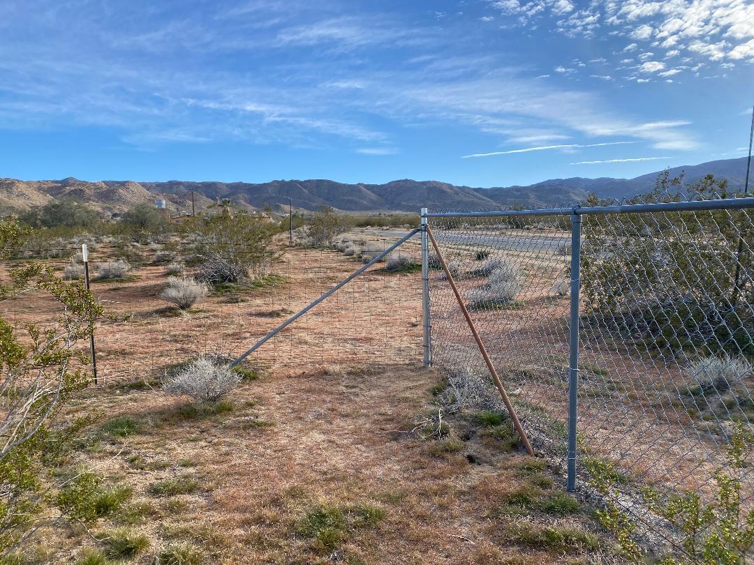 5457 Larrea Road Johnson Valley, CA 92285 - Photo 15 of 22 a view of a dry yard with wooden fence