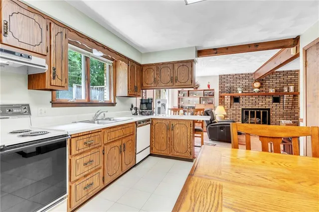 a kitchen with stainless steel appliances granite countertop a stove a sink dishwasher and a microwave oven with cabinets