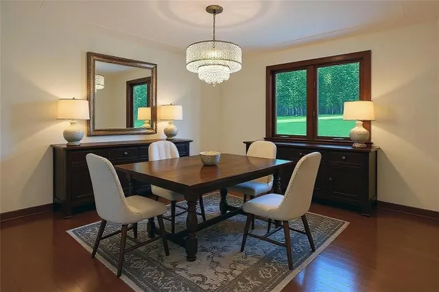 a view of a dining room with furniture a chandelier and wooden floor