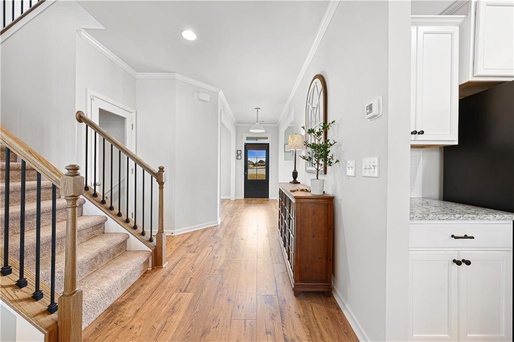 281 Greystone Court Winder, GA 30680 - Photo 11 of 71 a view of a hallway with wooden floor and staircase