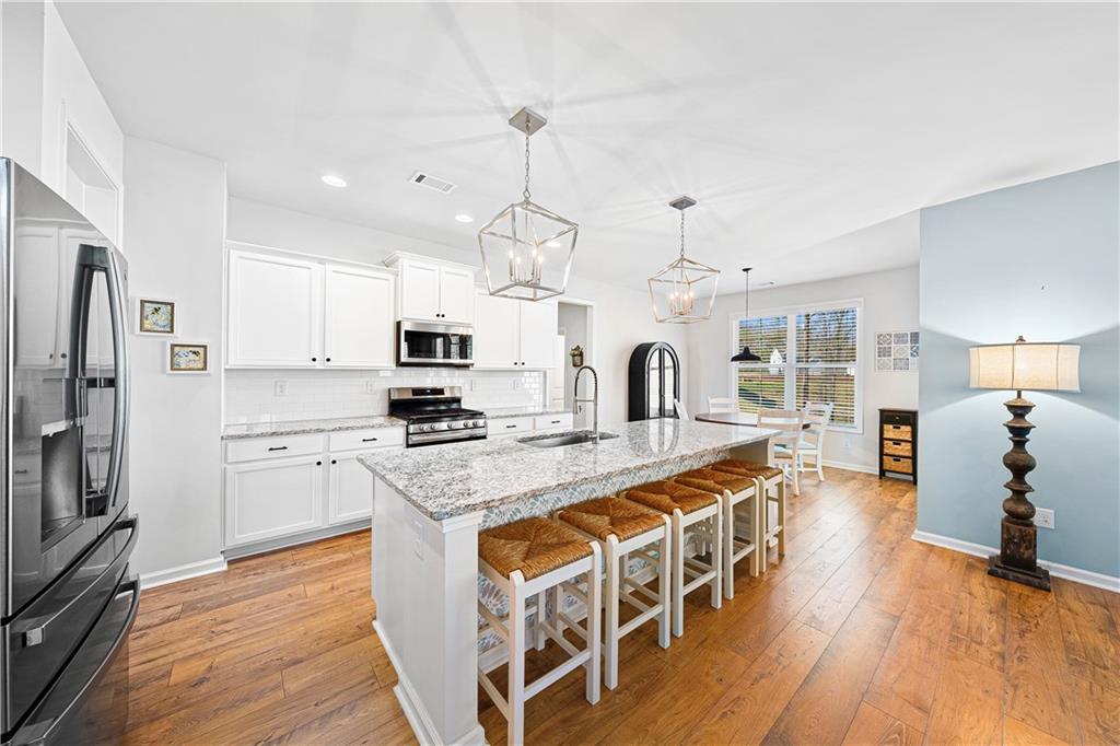 281 Greystone Court Winder, GA 30680 - Photo 15 of 71 a large kitchen with stainless steel appliances granite countertop a stove and a refrigerator