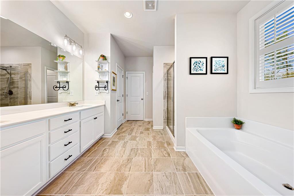 281 Greystone Court Winder, GA 30680 - Photo 31 of 71 a spacious bathroom with a tub sink and mirror
