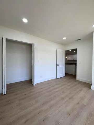 an empty room with wooden floor and closet