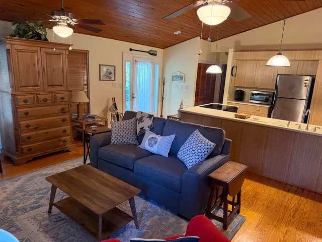 a living room with furniture a flat screen tv and kitchen view