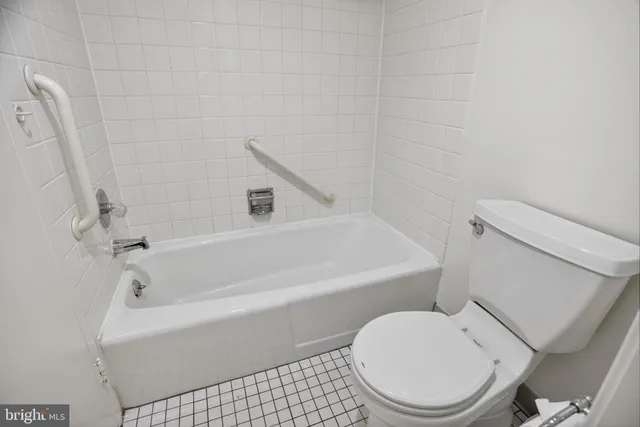 a white toilet sitting next to a bath tub