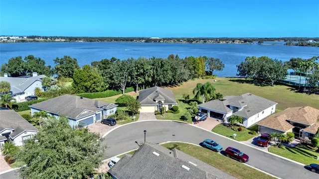 an aerial view of a house with a garden and lake view