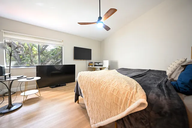 a bedroom with a bed and wooden floor