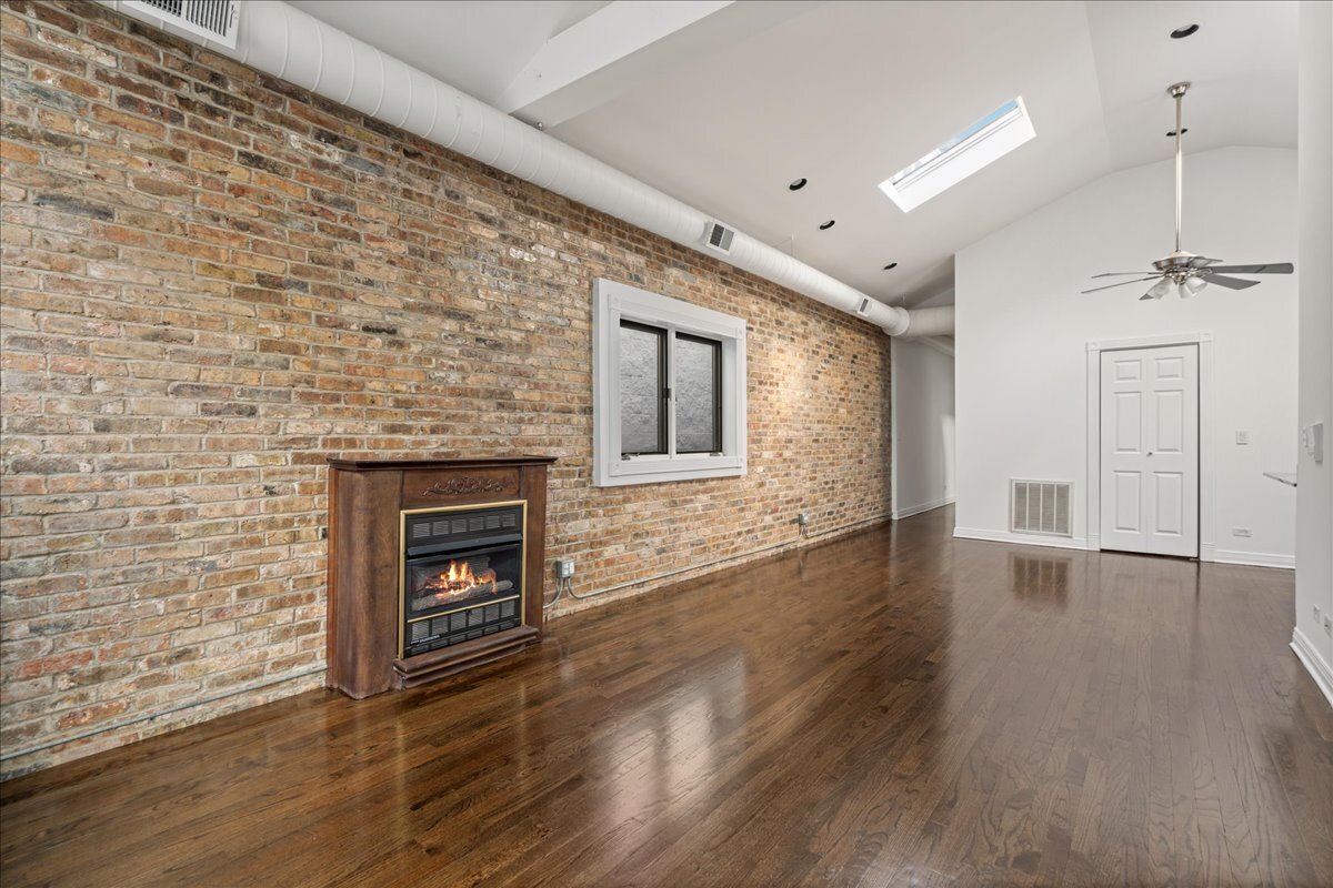 821 North Milwaukee Avenue, Unit 3 Chicago, IL 60642 - Photo 3 of 16 a view of a livingroom with wooden floor and a fireplace
