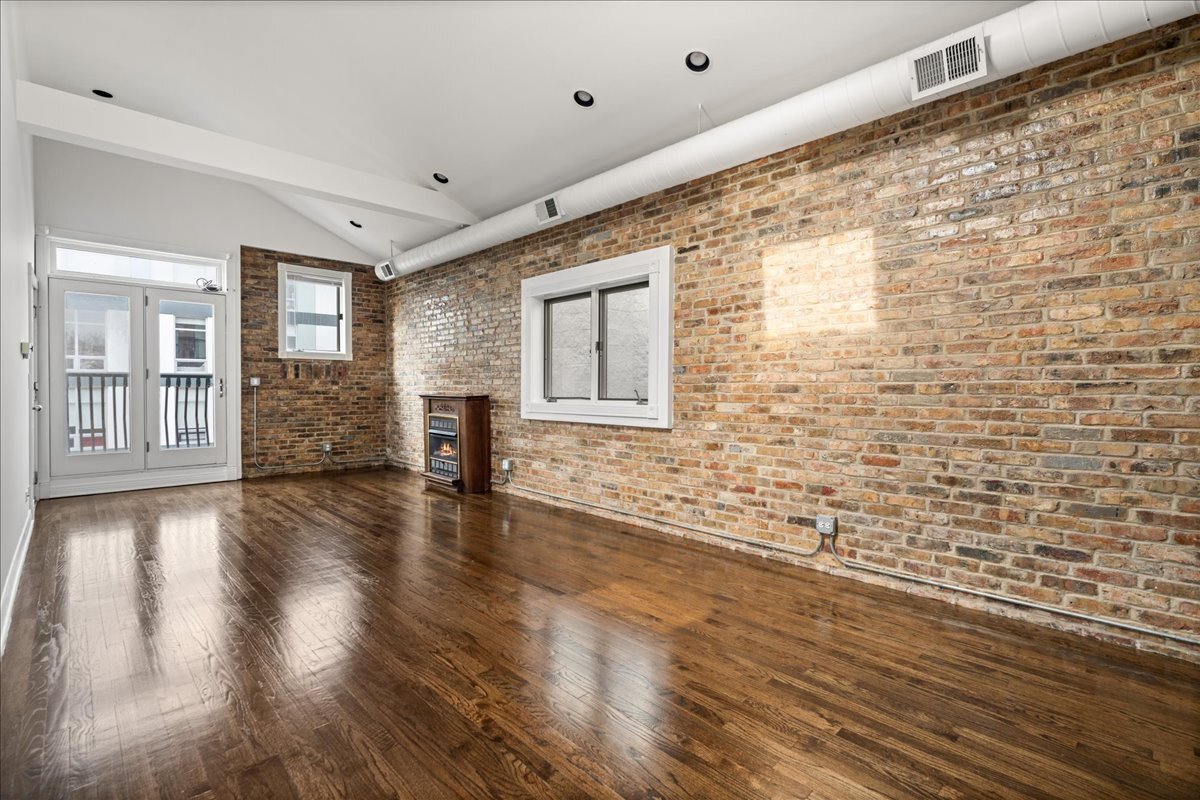 821 North Milwaukee Avenue, Unit 3 Chicago, IL 60642 - Photo 5 of 16 a view of an empty room with wooden floor and windows