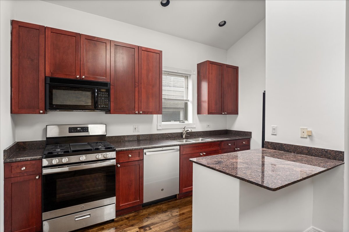 821 North Milwaukee Avenue, Unit 3 Chicago, IL 60642 - Photo 7 of 16 a kitchen with granite countertop a stove and a sink