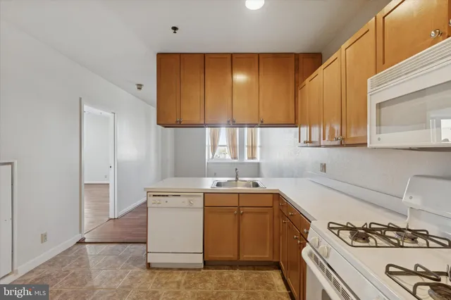 a kitchen with a sink stove top oven and cabinets