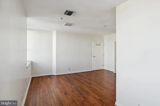 a view of an empty room with wooden floor