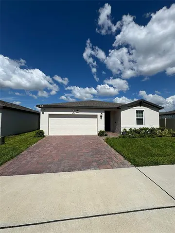 a front view of a house with a yard and a garage