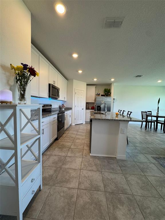 4836 Rigging Street Haines City, FL 33844 - Photo 11 of 29 a kitchen with kitchen island granite countertop a counter top space appliances and cabinets