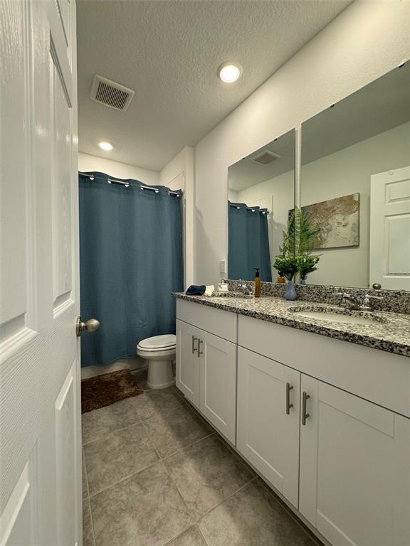 4836 Rigging Street Haines City, FL 33844 - Photo 22 of 29 a bathroom with a granite countertop sink a toilet a large mirror and shower