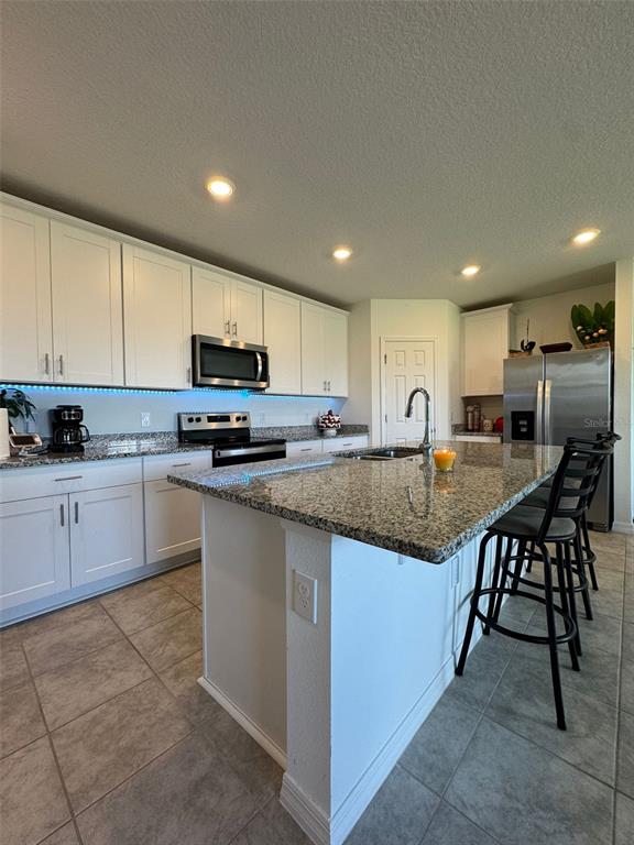 4836 Rigging Street Haines City, FL 33844 - Photo 6 of 29 a kitchen with stainless steel appliances granite countertop a stove a sink a microwave a refrigerator and cabinets