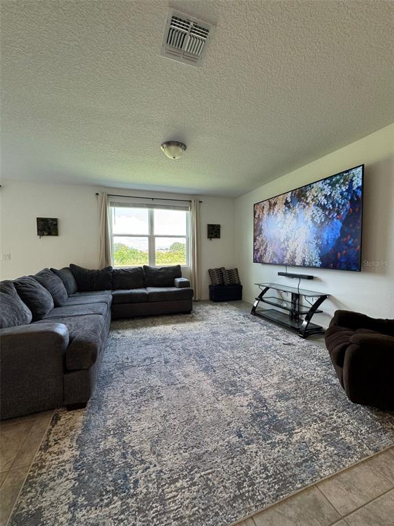 4836 Rigging Street Haines City, FL 33844 - Photo 9 of 29 a living room with furniture and a flat screen tv