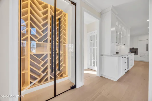 a large kitchen with stainless steel appliances kitchen island granite countertop a large window a oven and white cabinets