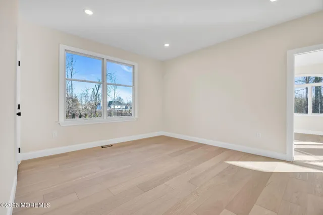 a view of a livingroom with a fireplace a chandelier and windows