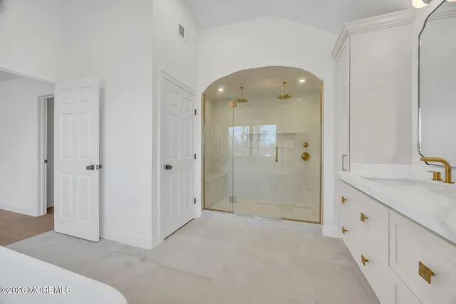 a view of a kitchen with kitchen island a sink wooden floor and a large window