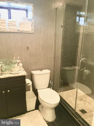 a bathroom with a granite countertop toilet a sink and shower