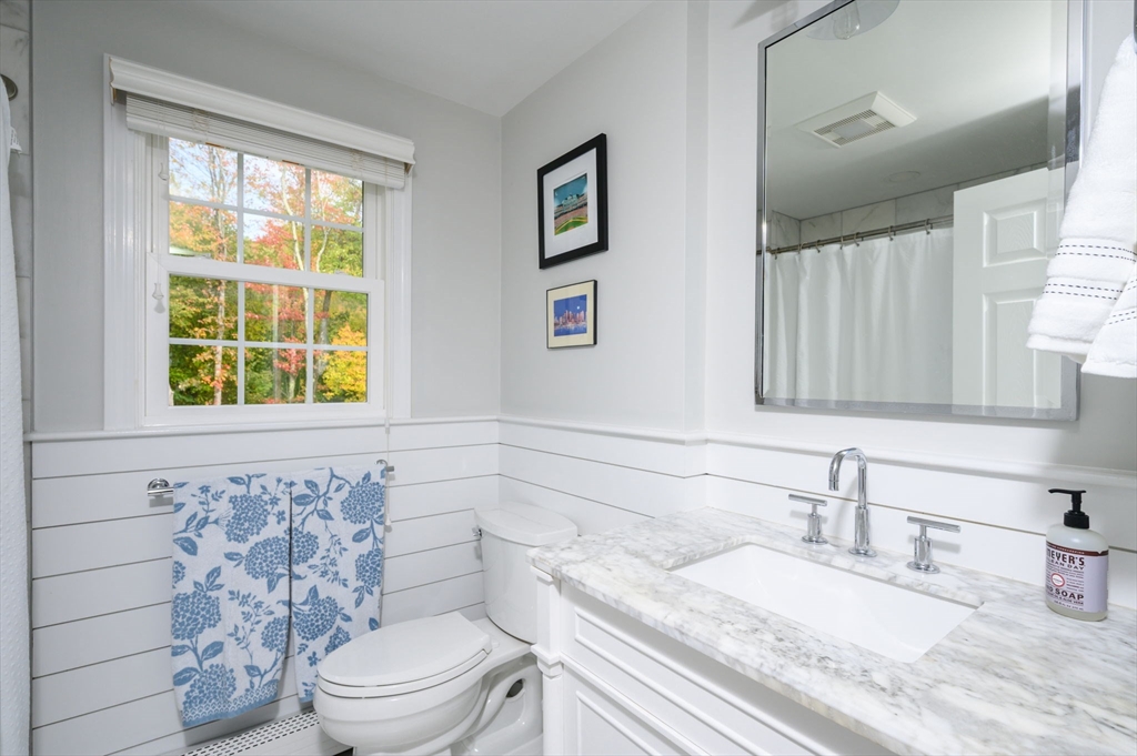 99 Doane Street Cohasset, MA 02025 - Photo 25 of 36 a bathroom with a granite countertop toilet a sink and a window