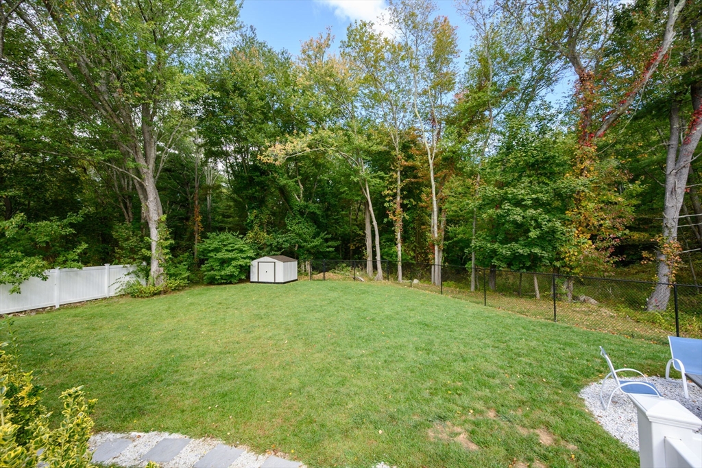 99 Doane Street Cohasset, MA 02025 - Photo 33 of 36 a backyard of a house with plants and large trees