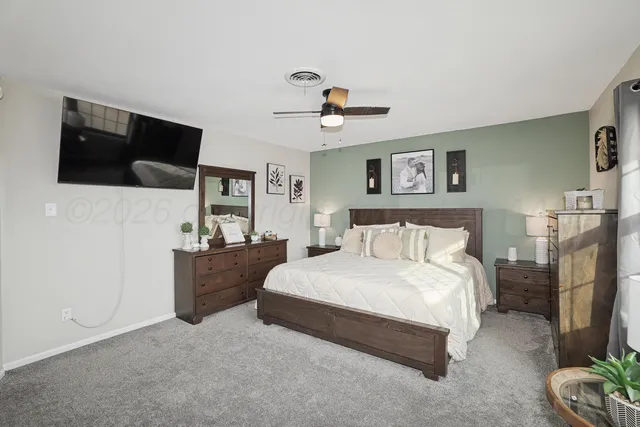 a spacious bedroom with a bed and a flat screen tv