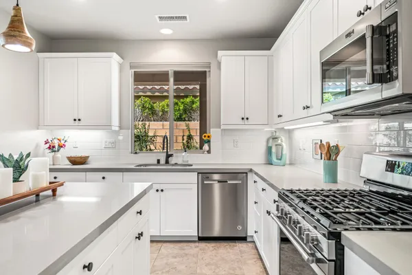 a kitchen with granite countertop a sink stove and cabinets
