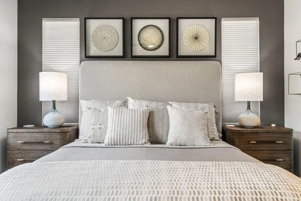 a bedroom with a bed and painting on the wall