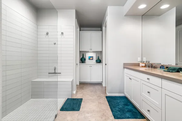 a bathroom with a double vanity sink a mirror and a bathtub