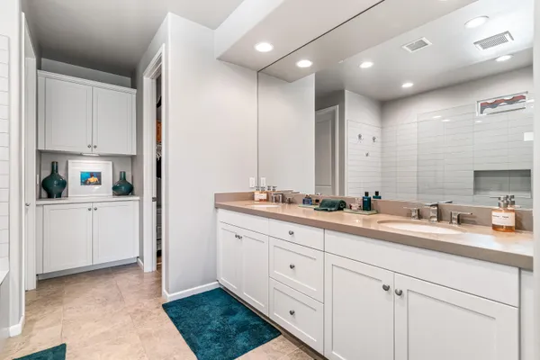 a spacious bathroom with a double vanity sink a mirror and shower