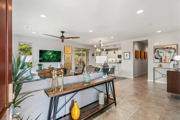 a living room with furniture a flat screen tv and a large window