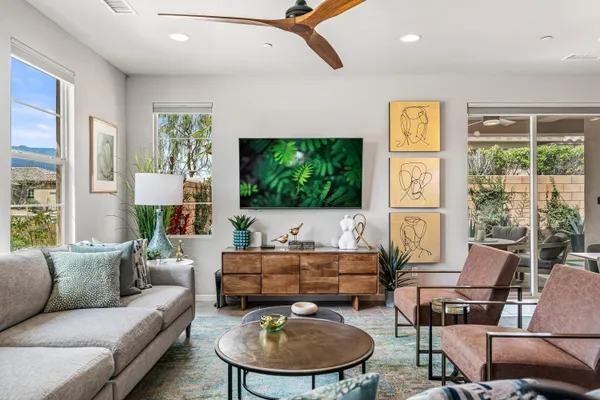 a living room with furniture a flat screen tv and a window